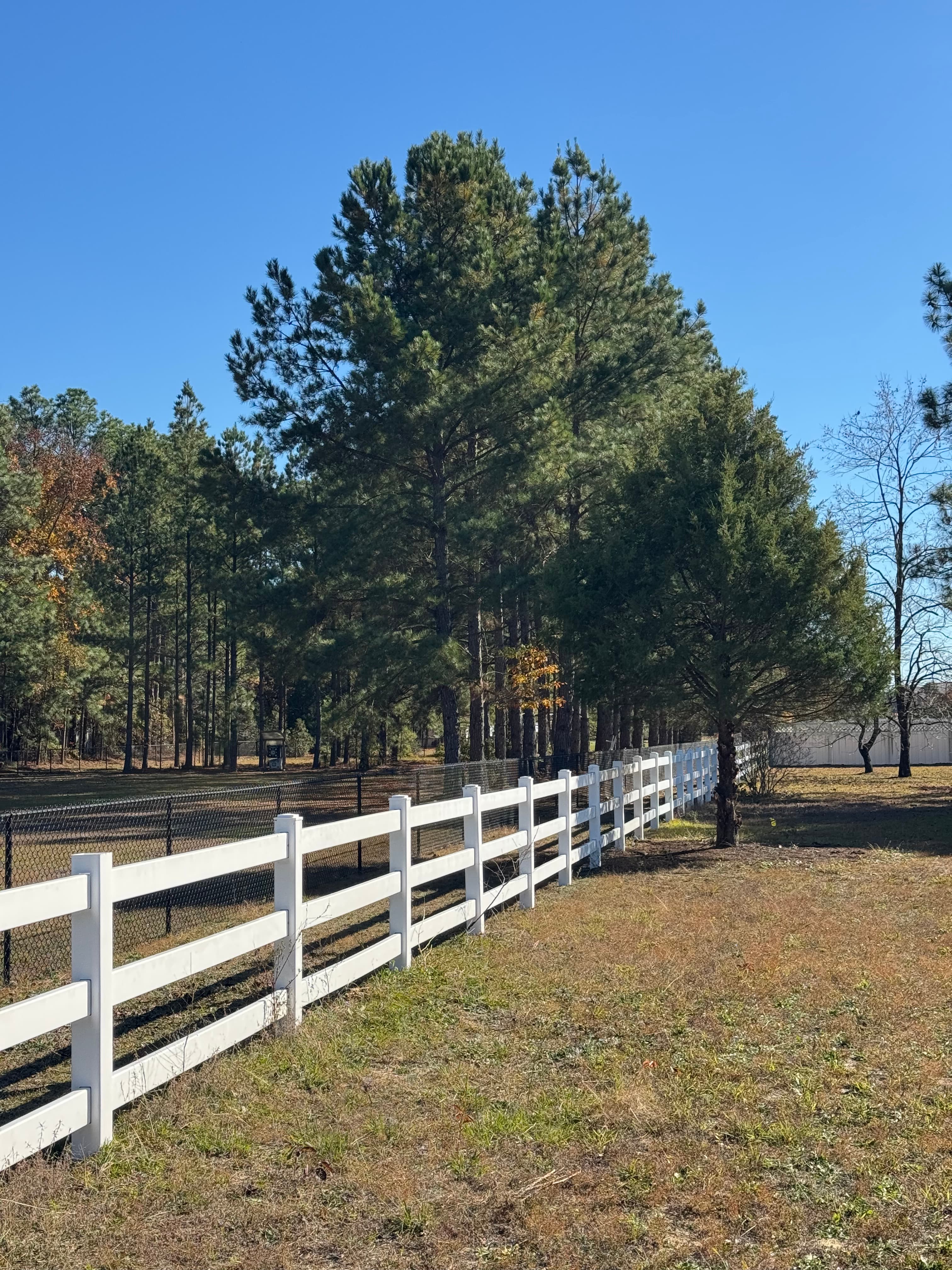 Clean white vinyl fence after soft washing by Max Pressure in Fayetteville NC