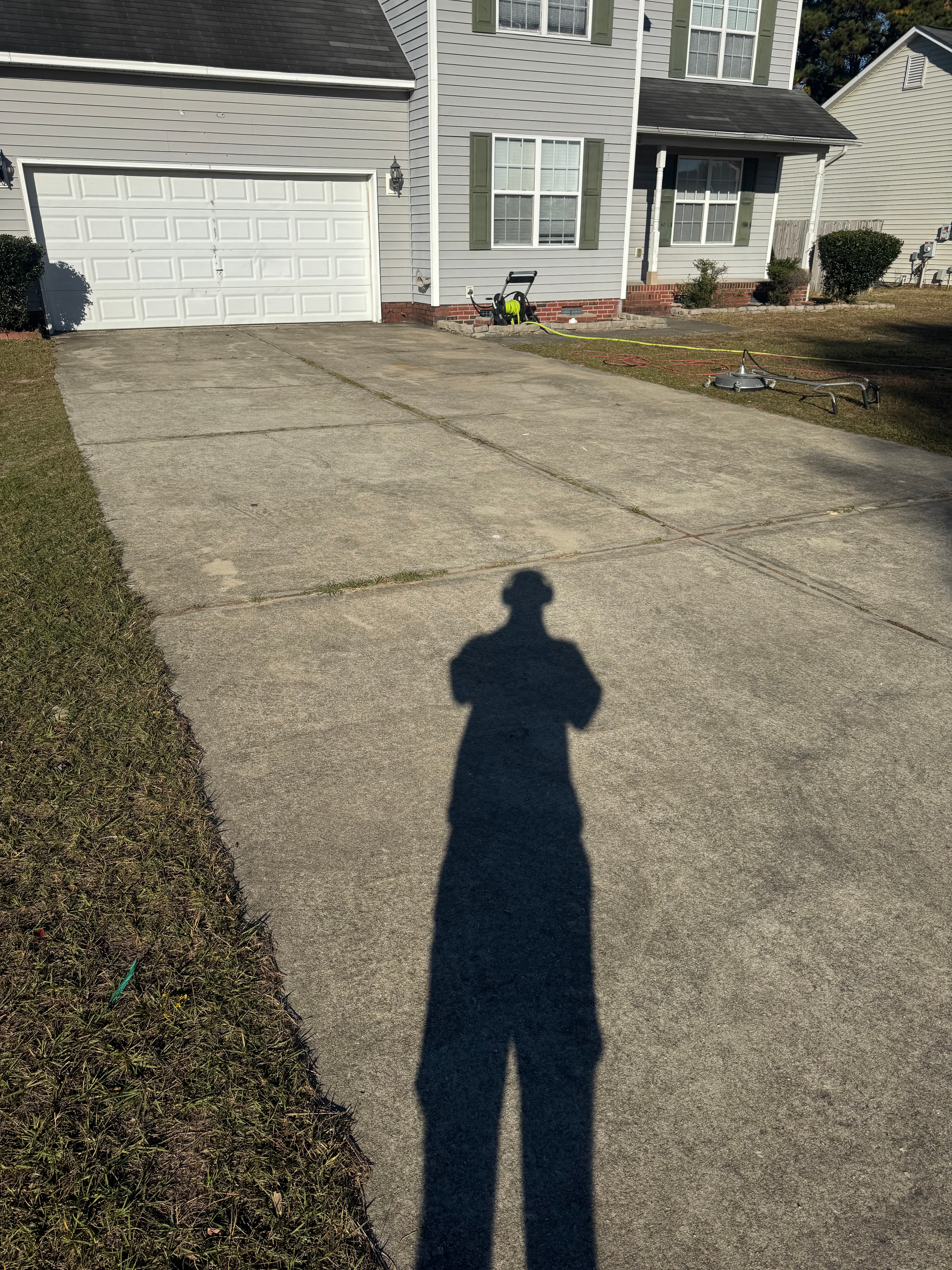 Concrete driveway with heavy staining and algae in Fayetteville NC before pressure washing