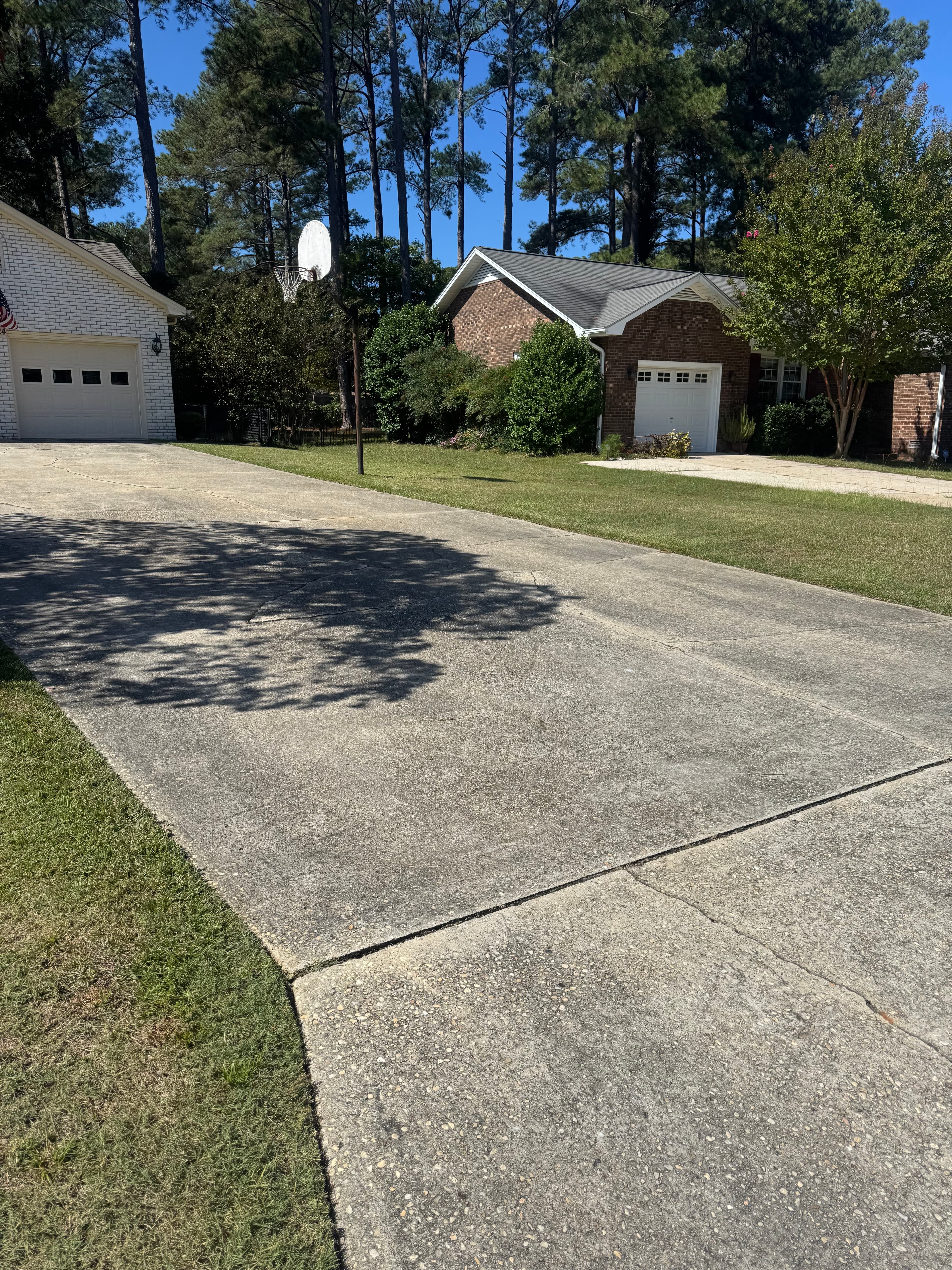 Concrete driveway with oil stains and NC red clay buildup in Fayetteville NC before pressure washing