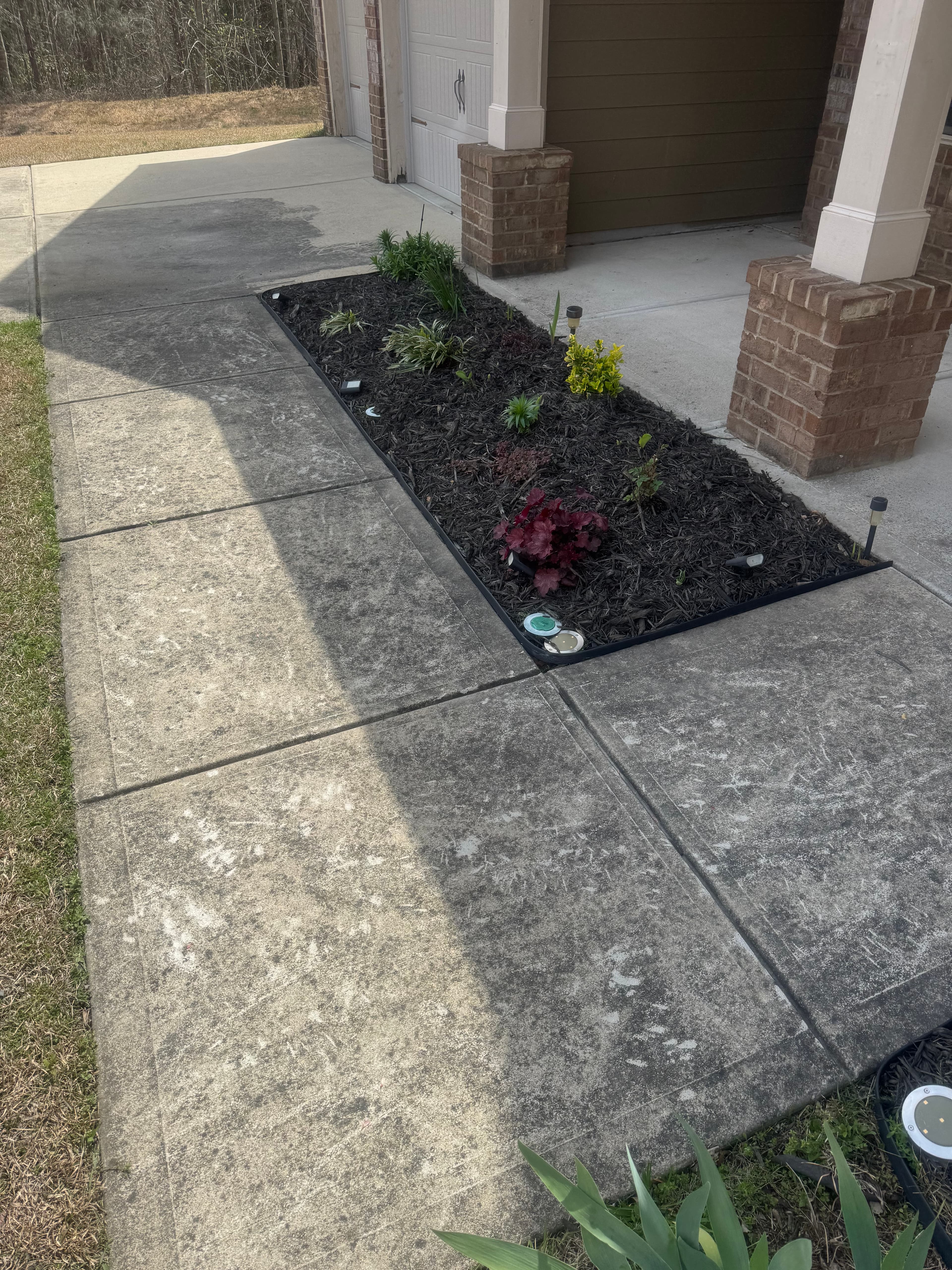 Concrete sidewalk with embedded dirt and staining in Fayetteville NC before pressure washing