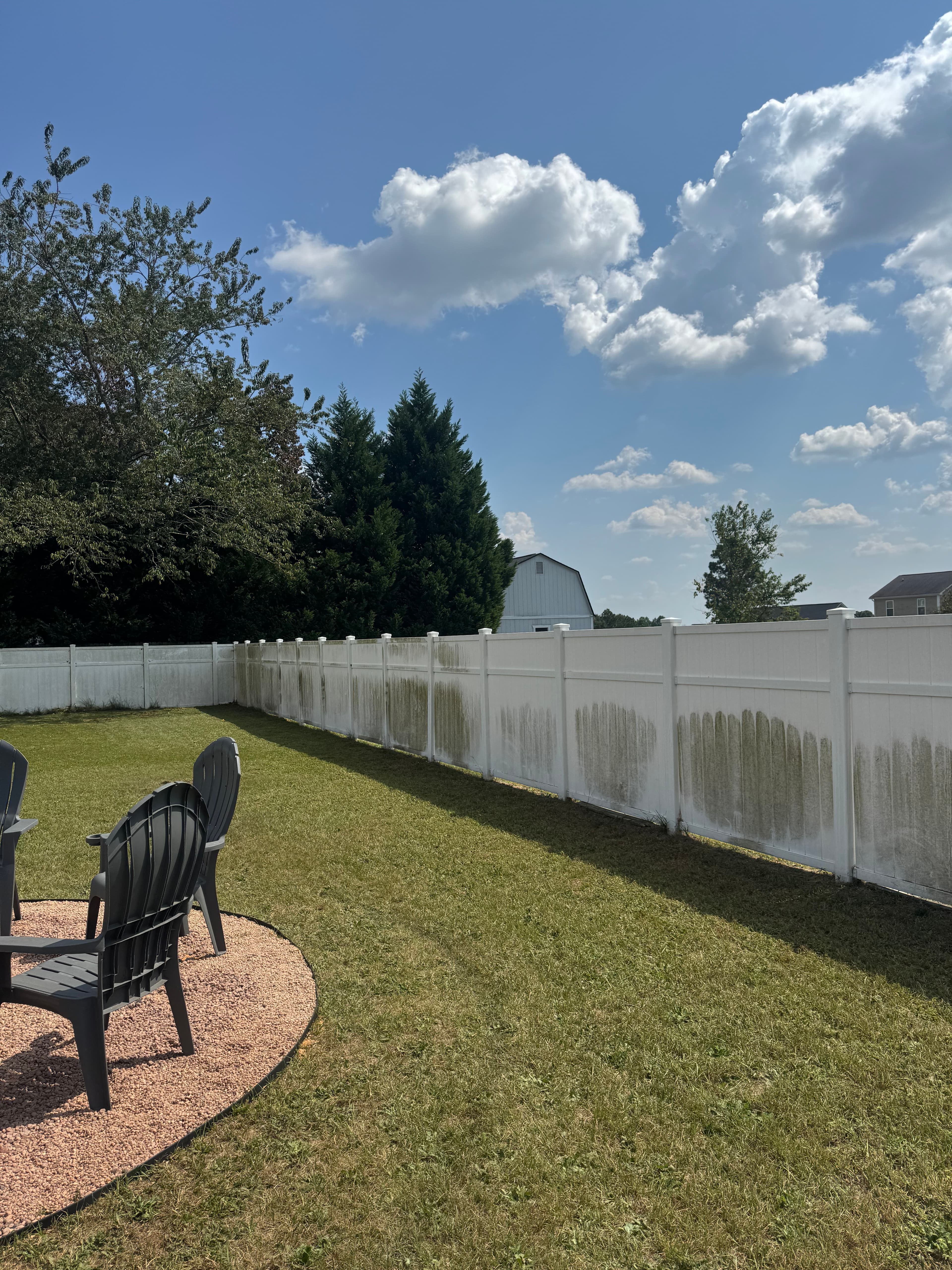 Vinyl fence with heavy green growth and discoloration in Fayetteville NC before soft washing