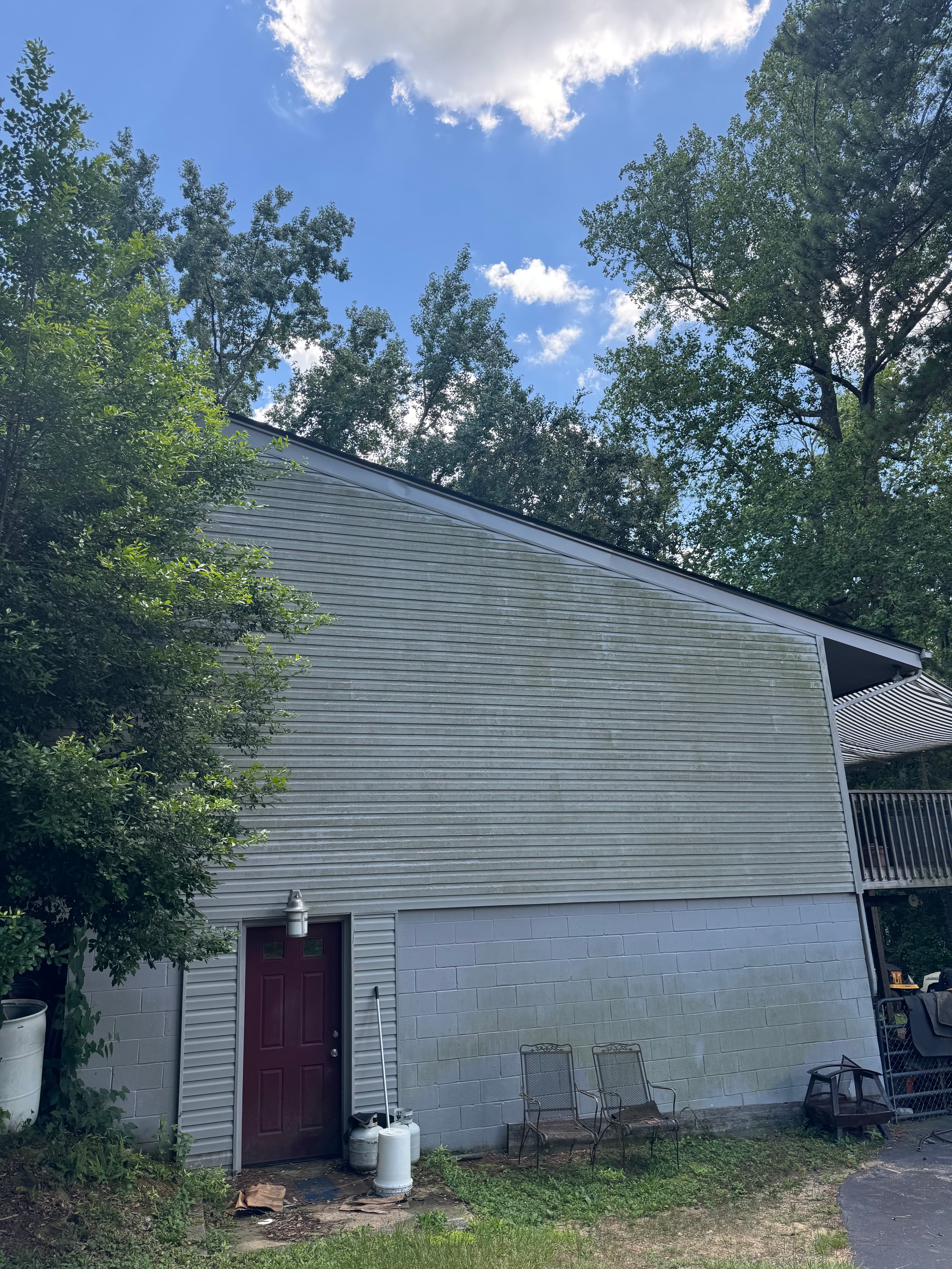 Home exterior with vinyl and brick siding covered in algae in Fayetteville NC